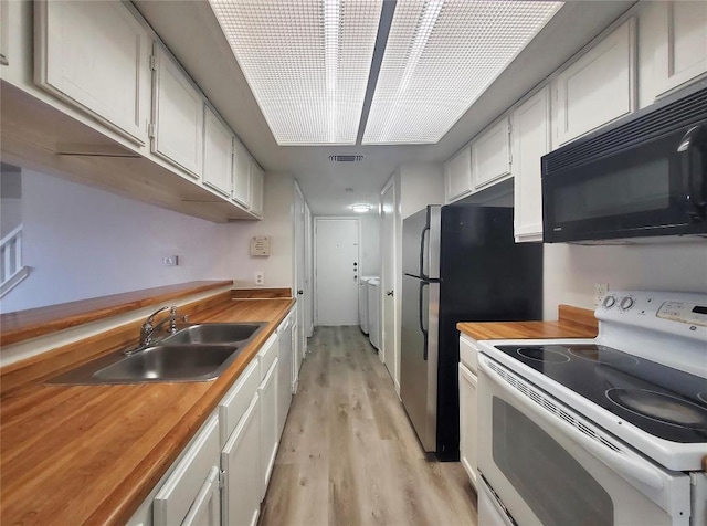 kitchen featuring white range with electric stovetop, visible vents, butcher block counters, black microwave, and a sink