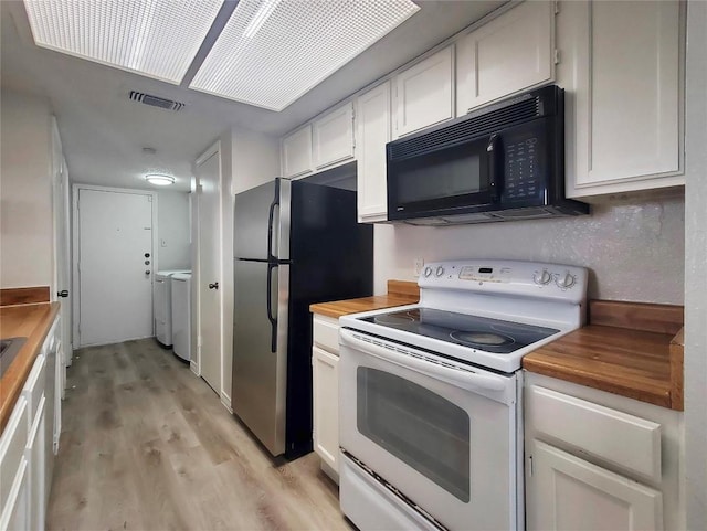 kitchen featuring visible vents, white range with electric stovetop, black microwave, and wood counters