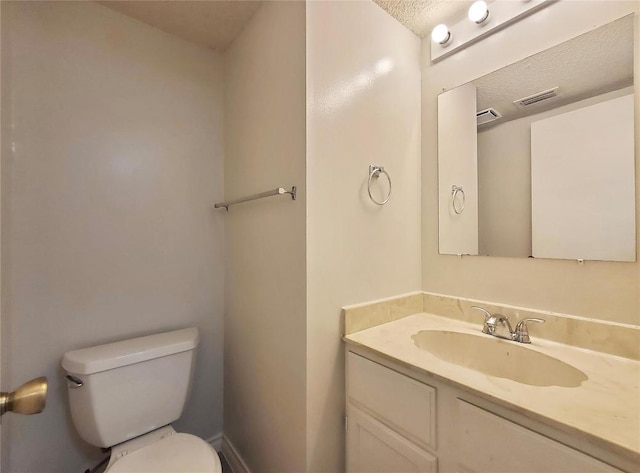 bathroom featuring toilet, visible vents, and vanity