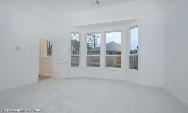 carpeted spare room with visible vents and baseboards