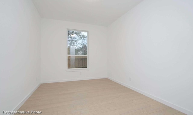 spare room with light wood-style flooring and baseboards