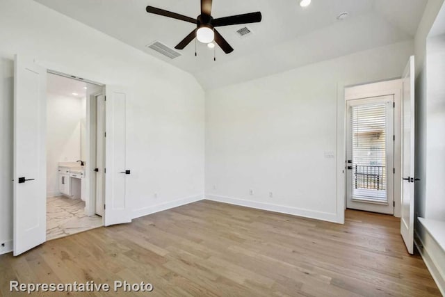 unfurnished bedroom featuring visible vents, light wood finished floors, baseboards, and lofted ceiling