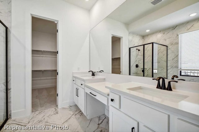 bathroom with a sink, a spacious closet, double vanity, a marble finish shower, and marble finish floor