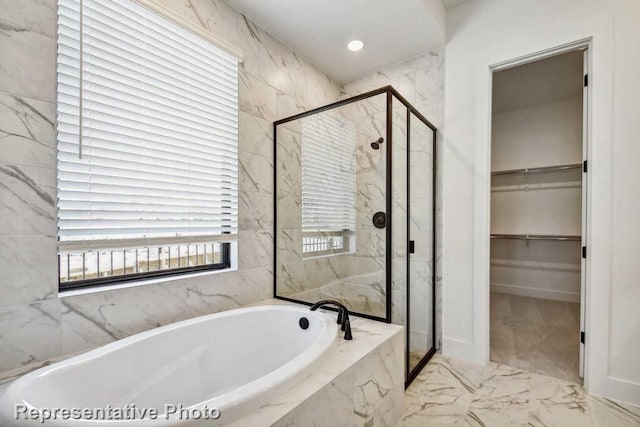 bathroom featuring a marble finish shower, a walk in closet, marble finish floor, and a garden tub
