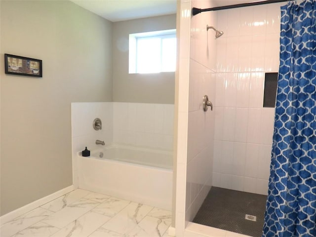 full bathroom featuring marble finish floor, a garden tub, a tile shower, and baseboards