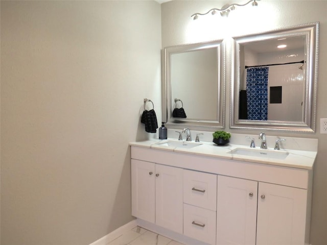 bathroom featuring marble finish floor, double vanity, a sink, and baseboards