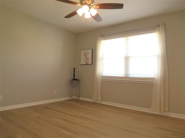 unfurnished room with baseboards, ceiling fan, and light wood-style floors