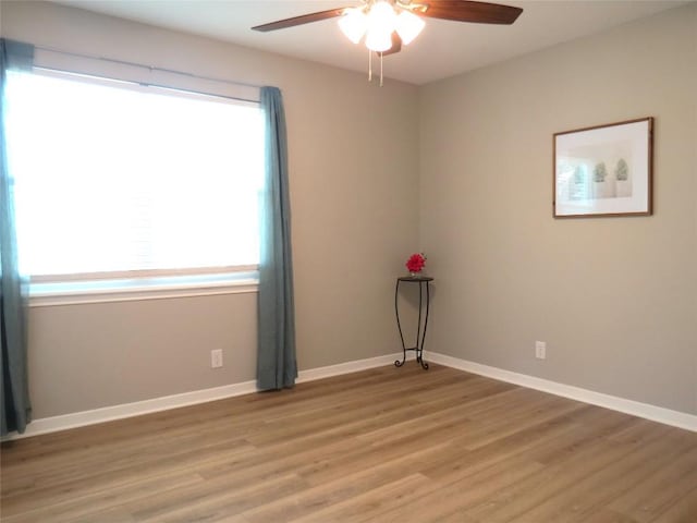 spare room with a ceiling fan, baseboards, and light wood finished floors