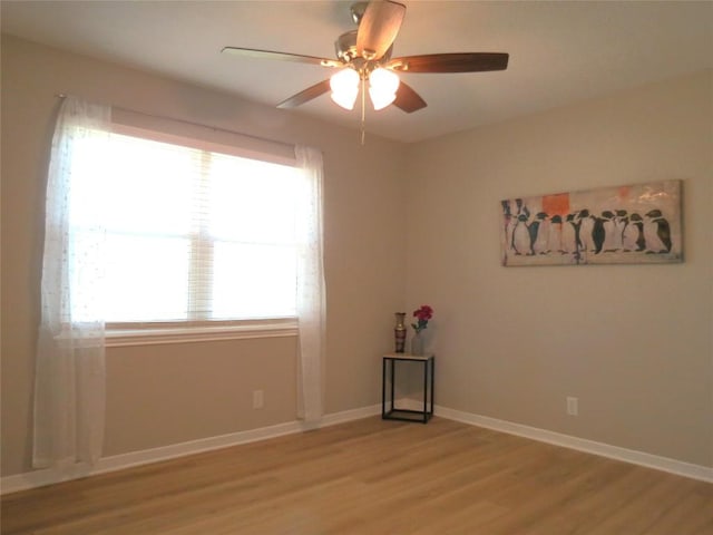 unfurnished room with baseboards, ceiling fan, and light wood-style floors