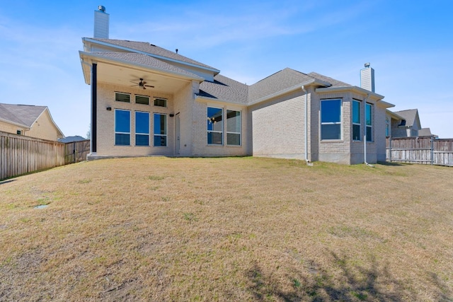 back of house with a chimney, a fenced backyard, and a ceiling fan