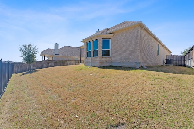 rear view of property with a yard, a fenced backyard, and brick siding