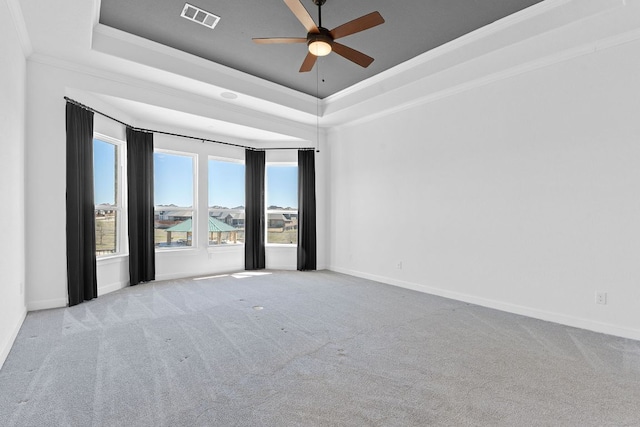 spare room featuring ornamental molding, a tray ceiling, carpet, and visible vents