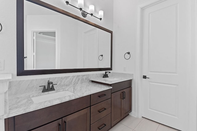 bathroom featuring tile patterned flooring, a sink, and double vanity