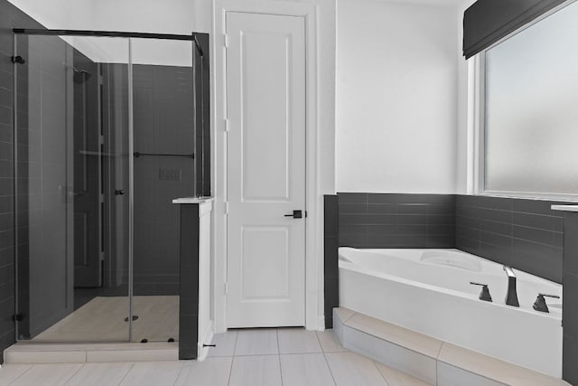 bathroom with a garden tub, a shower stall, and tile patterned floors