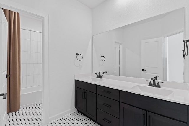 full bath with shower / bath combination, a sink, baseboards, and double vanity