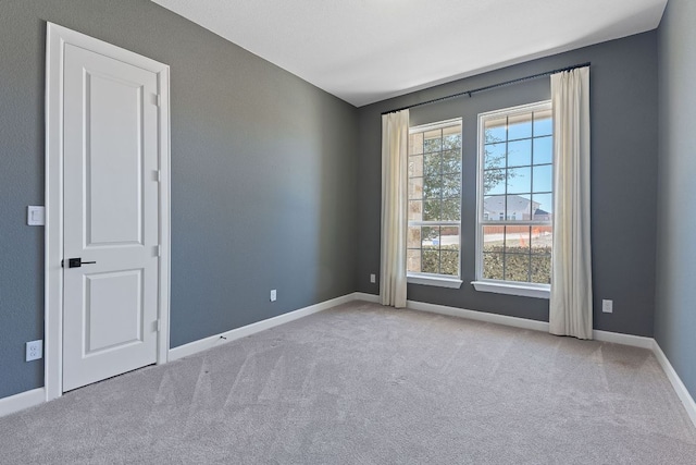 carpeted empty room with baseboards