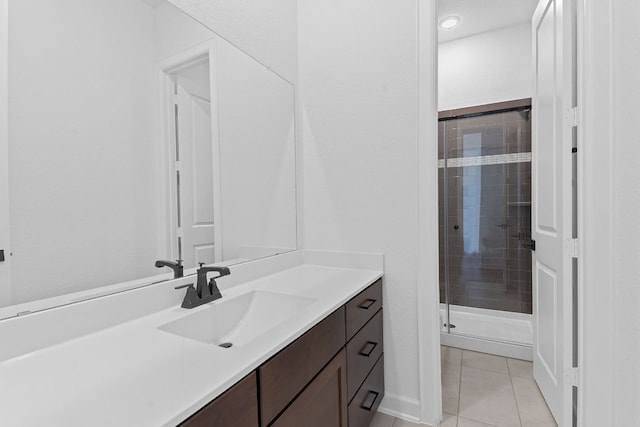 bathroom featuring tile patterned flooring, vanity, and a shower stall