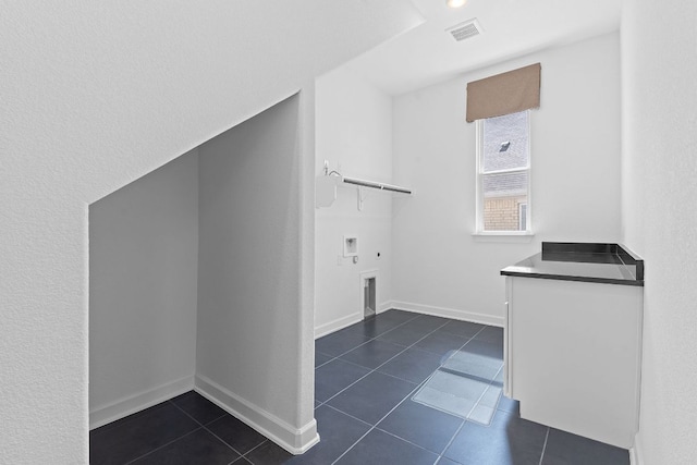 washroom featuring baseboards, dark tile patterned floors, visible vents, and electric dryer hookup