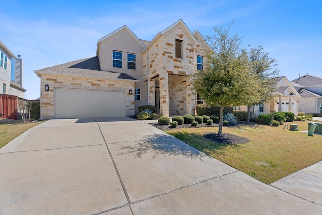 view of front facade featuring stone siding, a front yard, fence, and driveway