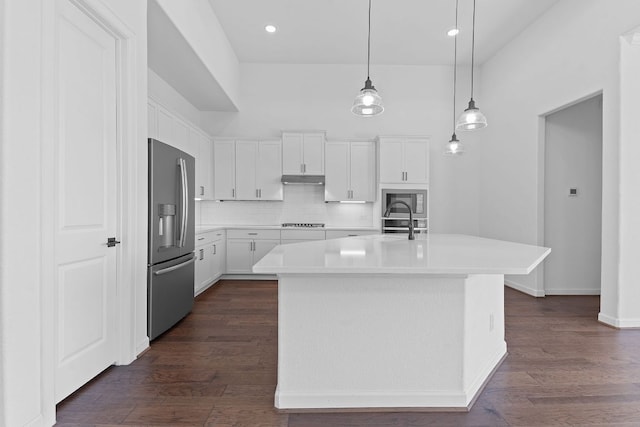 kitchen featuring tasteful backsplash, white cabinets, appliances with stainless steel finishes, dark wood-style flooring, and light countertops