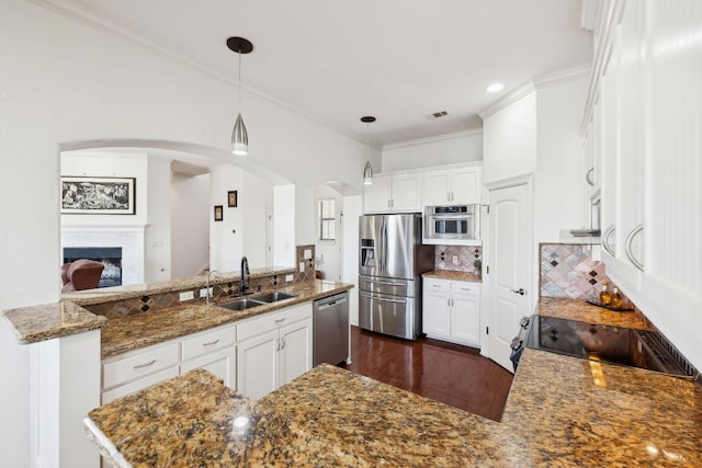 kitchen featuring crown molding, stainless steel appliances, tasteful backsplash, visible vents, and a sink