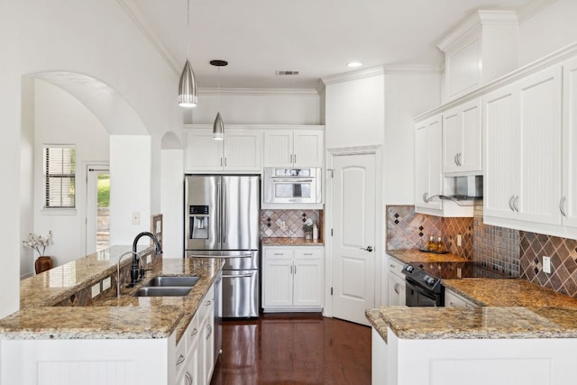 kitchen with arched walkways, a sink, appliances with stainless steel finishes, light stone countertops, and crown molding