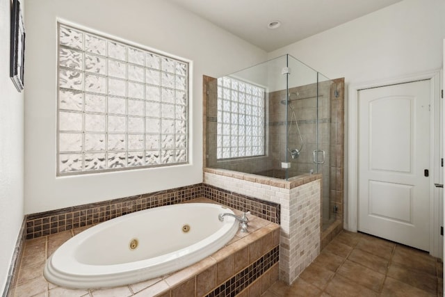 full bath featuring a jetted tub, a stall shower, and tile patterned floors