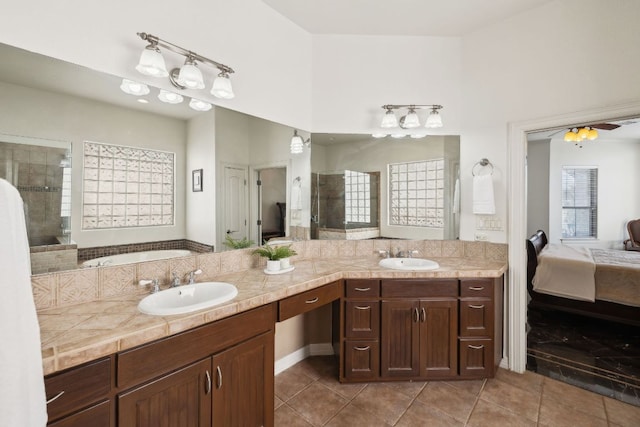 ensuite bathroom with a stall shower, a sink, and tile patterned floors