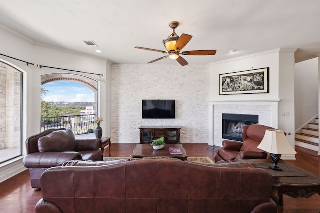 living area with visible vents, stairway, a fireplace with flush hearth, ceiling fan, and wood finished floors