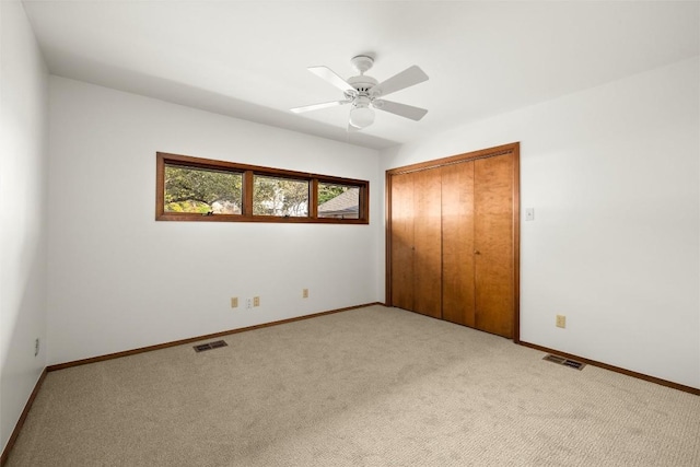 unfurnished bedroom featuring light carpet, baseboards, visible vents, and a closet