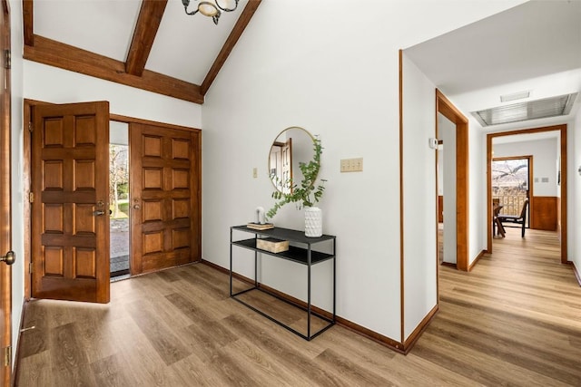 foyer featuring beam ceiling, visible vents, light wood-style flooring, and baseboards