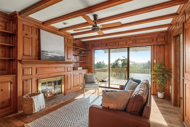 interior space with wood walls, a fireplace with flush hearth, and light wood-style flooring