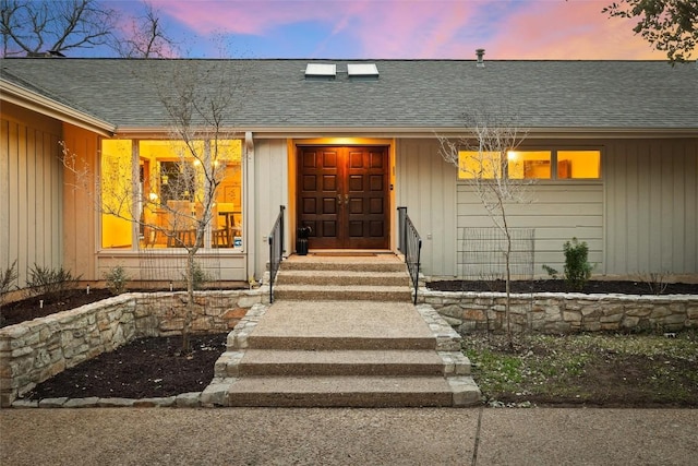 exterior entry at dusk with roof with shingles