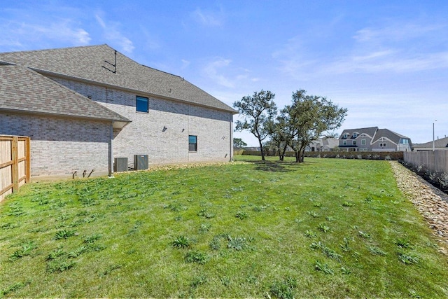 view of yard with fence and central AC