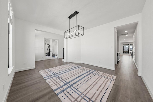 interior space with recessed lighting, an inviting chandelier, baseboards, and dark wood-type flooring