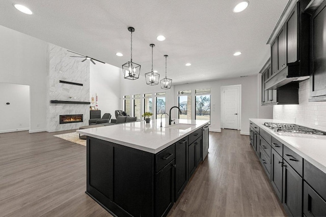 kitchen featuring light countertops, recessed lighting, baseboards, and a sink