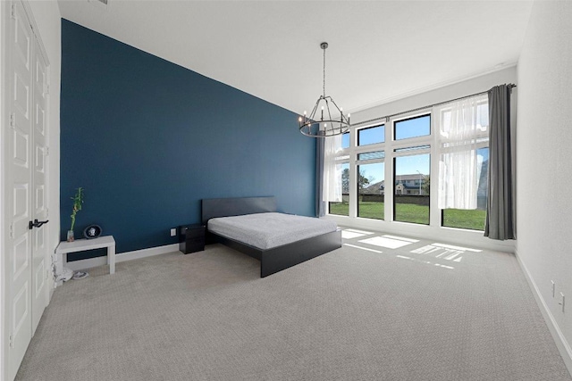 bedroom featuring a closet, an inviting chandelier, carpet floors, and baseboards