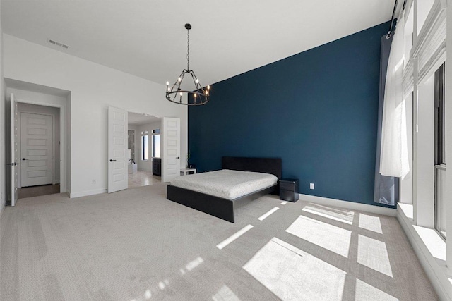 unfurnished bedroom featuring a chandelier, visible vents, light colored carpet, and baseboards