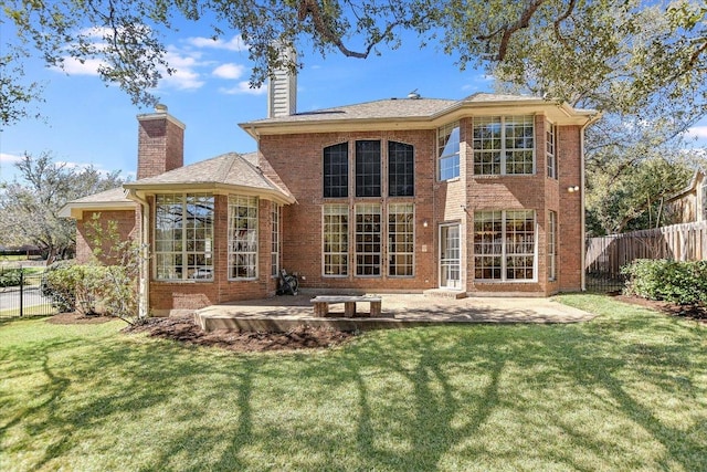 back of property with a patio, brick siding, fence, a lawn, and a chimney