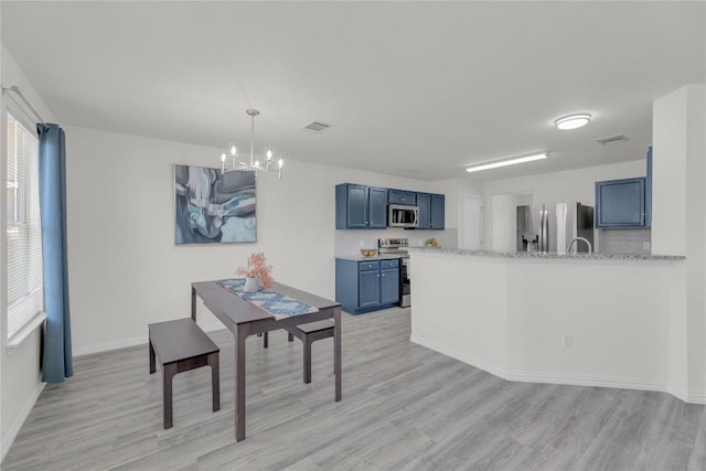 dining space featuring an inviting chandelier, light wood-style flooring, and visible vents