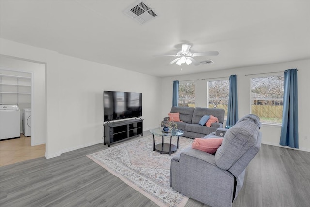 living room with a wealth of natural light, washing machine and dryer, and visible vents