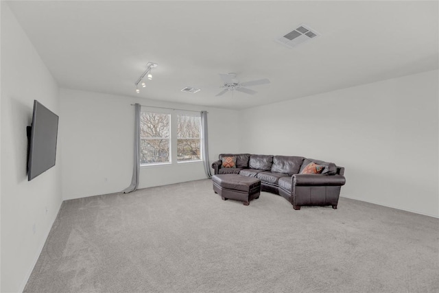 living room featuring carpet, visible vents, and a ceiling fan