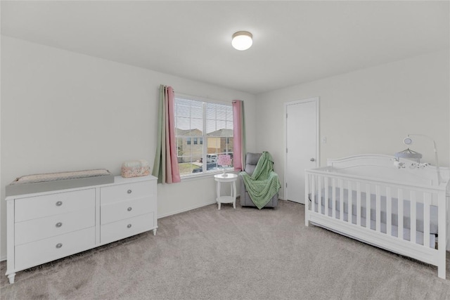 carpeted bedroom with a nursery area