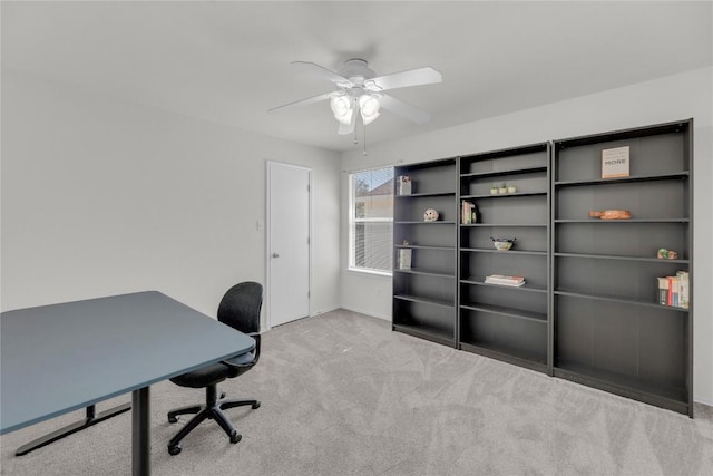 carpeted office space featuring a ceiling fan