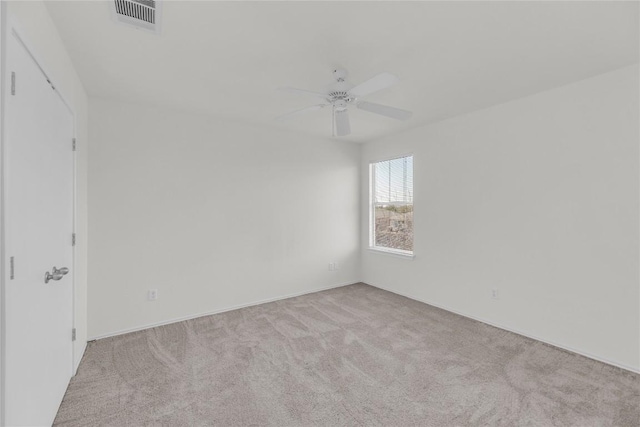 carpeted spare room featuring visible vents and a ceiling fan