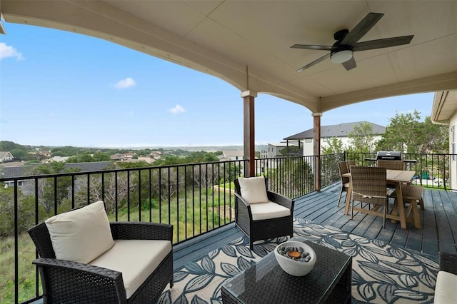 deck featuring outdoor dining area, grilling area, and a ceiling fan