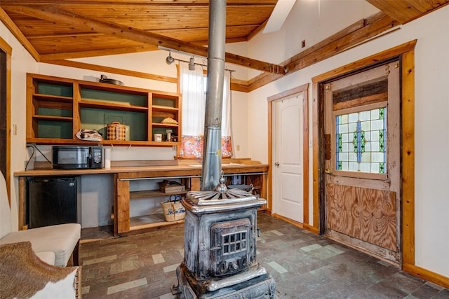 interior space with a wood stove, wood ceiling, baseboards, and refrigerator