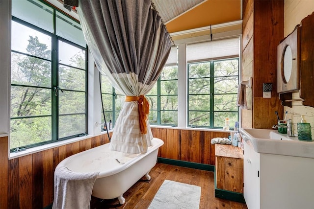 sunroom / solarium featuring plenty of natural light, vaulted ceiling, and a sink