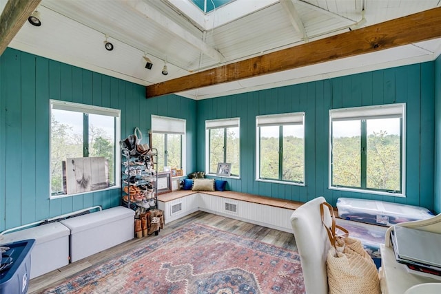 sunroom with a skylight, visible vents, beamed ceiling, and rail lighting