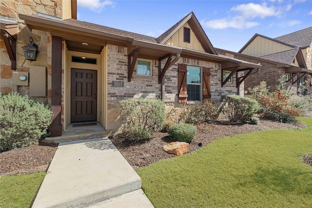 entrance to property with a lawn, board and batten siding, and brick siding